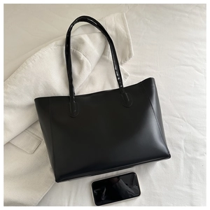 Détail du sac cabas minimaliste en cuir PU noir montrant la texture lisse et l'intérieur