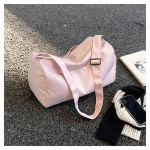 Pink waterproof travel bag with adjustable strap and top zipper shown in a top-down view