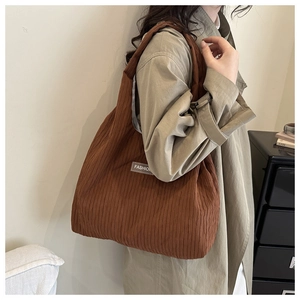 Détail du sac cabas en velours côtelé marron avec une texture plissée et étiquette