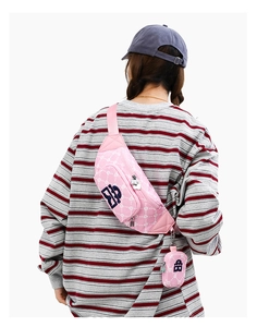 Sac bandoulière rose matelassé avec pochette amovible porté par un mannequin