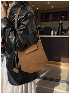 Sac à bandoulière en daim marron avec cordon de serrage dans un décor de café
