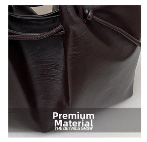 Detailed close-up of dark brown tote bag showing premium leather texture and pleated crafts