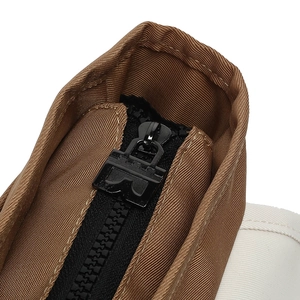 Close-up of contrast color canvas messenger bag with durable nylon zipper and metal puller