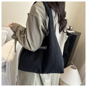Détail du grand sac cabas en velours côtelé noir avec étiquette mode sur mannequin