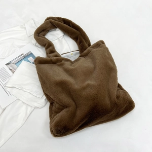 Detail of plush brown faux fur tote bag showing the gold metal snap closure and lining