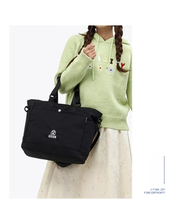 Dettaglio di una borsa tote in nylon nero leggero con logo RUIZH e tracolla inclusa