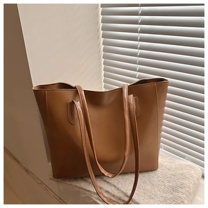 Détail du cabas caramel montrant la texture du cuir mat et les coutures renforcées