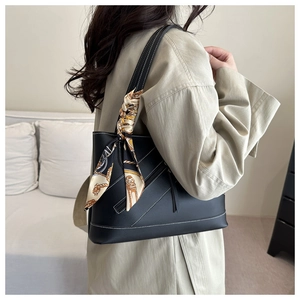 Detail of black tote bag with white contrast stitching and vintage patterned silk scarf