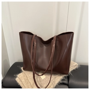 Détail du grand sac cabas en cuir marron foncé avec finition mate et longues bandoulières