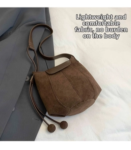 Détail du sac seau marron foncé en daim avec bordure en cuir et cordon décoratif