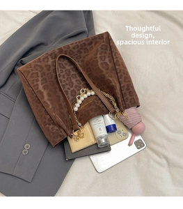 Deep brown leopard print tote bag interior with pearl chain handle and daily essentials