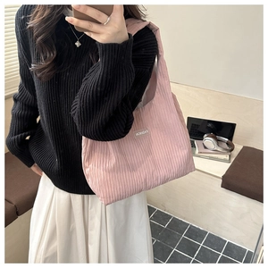 Détail de la texture plissée du sac cabas rose montrant le tissu souple et l'étiquette