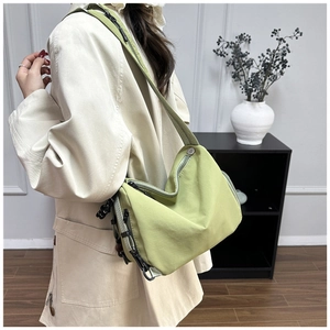 Detailed view of light green nylon crossbody bag showing water-resistant texture and straps