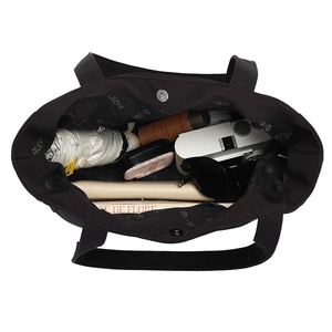 Black large capacity tote bag showing spacious interior with everyday essentials