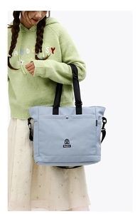 Dettaglio della borsa tote in nylon celeste con bottone a pressione e tracolla in tessuto