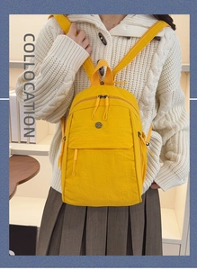 Bright yellow nylon multi-functional backpack shown on model in cozy home setting