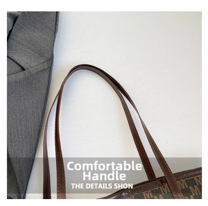 Close-up of leather handles and double stitching on brown monogram tote bag
