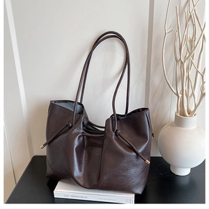 Close-up of brown PU leather tote bag details with drawstring and metal metal tips