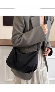 Close-up of black nylon crossbody tote bag showing light weight fabric and pleated texture