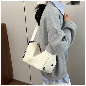 Close-up of the stylish cream nylon hobo bag showing soft texture and side pocket detail