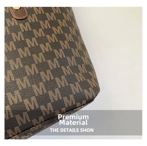 Close-up of brown monogram tote bag fabric with textured finish and gold rivet details