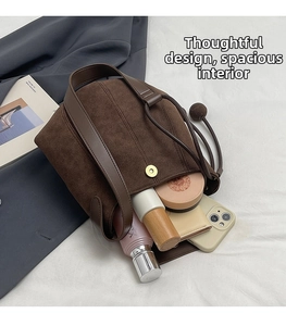 Intérieur spacieux du sac seau en daim marron foncé avec téléphone et cosmétiques