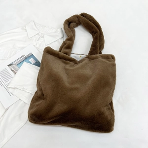 Detail of brown faux fur tote bag showing the magnetic buckle and soft texture