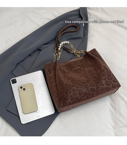 Leopard print tote bag with pearl chain handle showing interior space for iPad and phone
