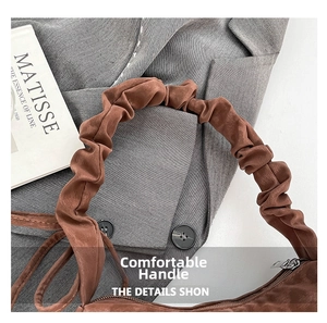 Detail of soft pleated brown suede texture on a stylish minimalist shoulder bag