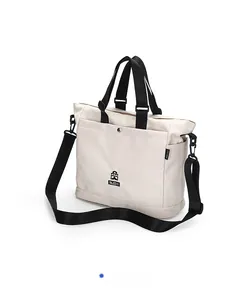 Dettaglio laterale della borsa tote in nylon beige con tasca e tracolla nera regolabile