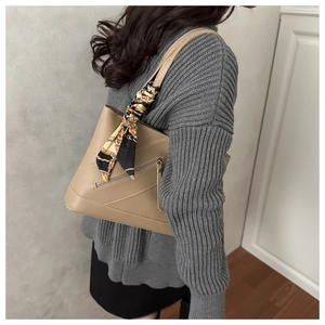 Detail of light khaki tote bag with zipper pocket and printed silk scarf accessory