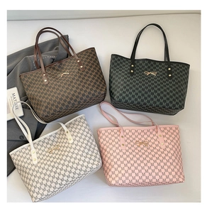 Flat lay of four monogrammed tote bags with metal bow details in various colors