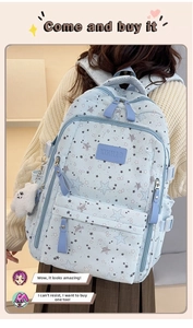 Detail of light blue backpack with star patterns and white plush pendant accessory