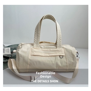 Detail view of large beige fitness bag showing textured nylon fabric and shoulder strap