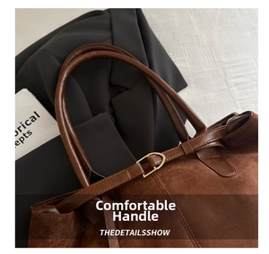 Detail of brown faux suede tote bag with cylindrical leather handles and gold metal buckle