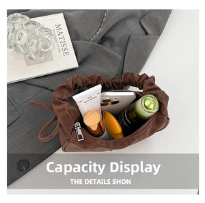 Internal capacity of the brown pleated handbag showing phone and cosmetics layout