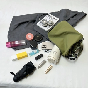 Green nylon crossbody bag showing large storage capacity for water bottle and umbrella