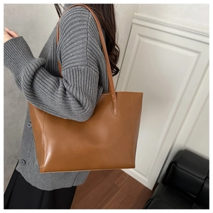 Grand sac cabas en cuir marron porté par un mannequin pour un style minimaliste