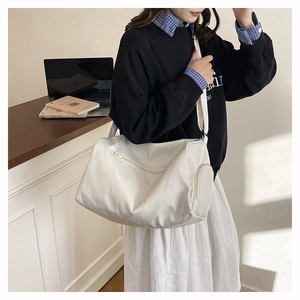 Close-up of a white large-capacity shoulder bag with zipper detail for gym and travel