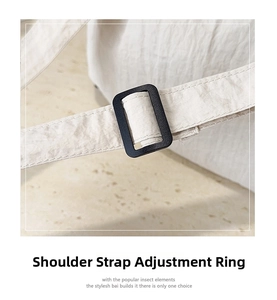 Detail of adjustable shoulder strap with black plastic buckle on white nylon tote bag