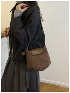 Détail du sac seau citrouille vintage en daim marron avec rabat en cuir et pendentif