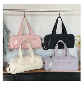 Close-up of waterproof gym bags in pink, black, cream, and purple with durable straps