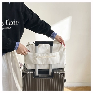 White travel bag featuring a trolley sleeve with a zipper pocket for luggage attachment