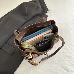 Brown leather tote bag with printed silk scarf showing spacious multi-compartment interior