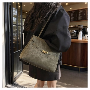 Detail view of the vintage dark green shoulder bag featuring a classic gold twist-lock closure