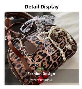 Detail of leopard print handbag with brown leather trim and pearl heart charm accessory