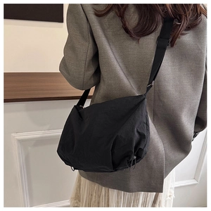 Close-up of black nylon tote bag showing soft cloud-like structure and pleated texture
