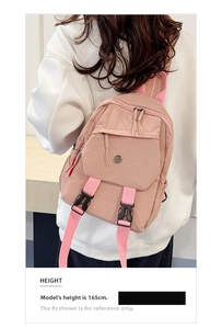 Pink waterproof nylon mini backpack featuring decorative buckles and a side pocket detail