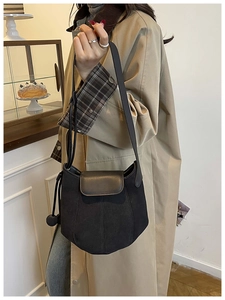 Détail du sac seau citrouille noir montrant le mélange de daim mat et de cuir lisse élégant