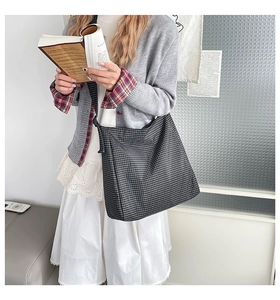 Détail du sac cabas en toile à carreaux avec bandoulière réglable au style décontracté